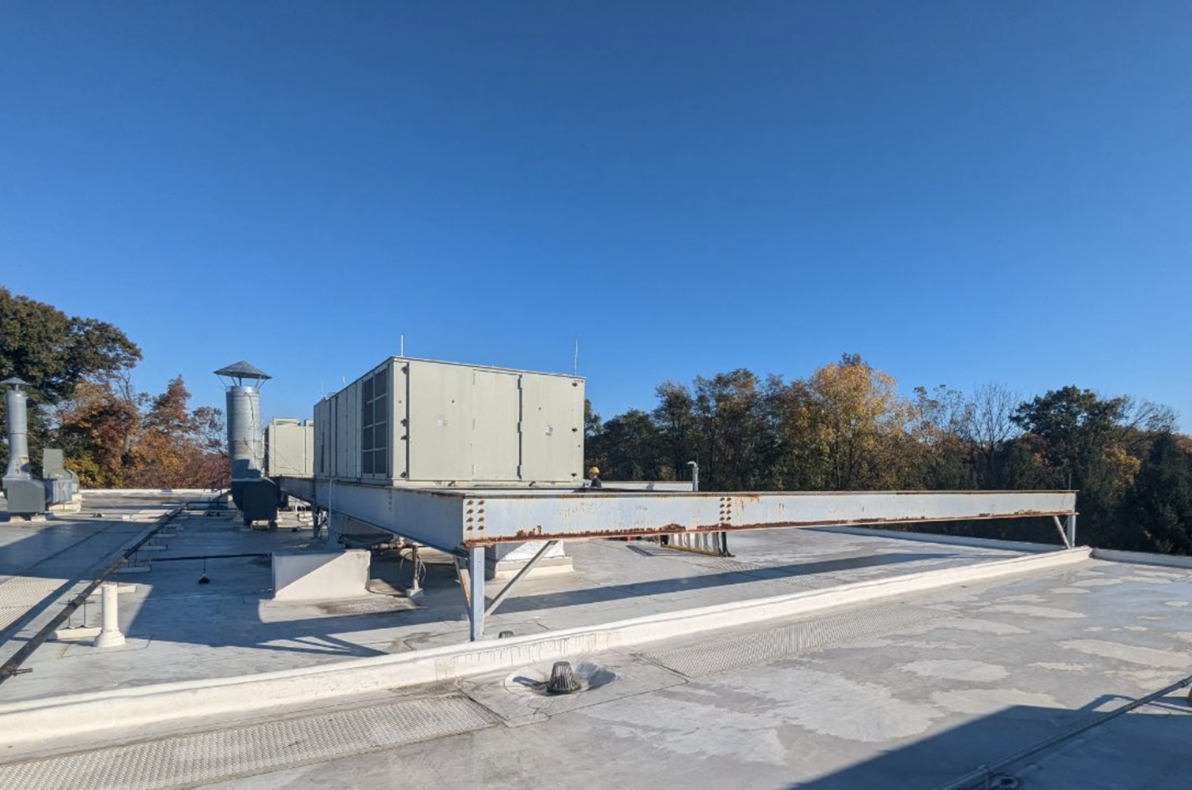 Before picture of rooftop steel support beams showing rust