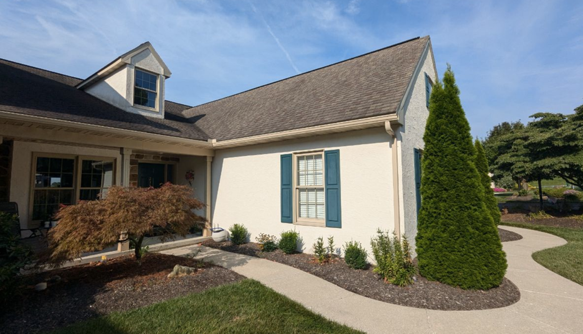 Single story home featuring beige stucco with blue window shutters