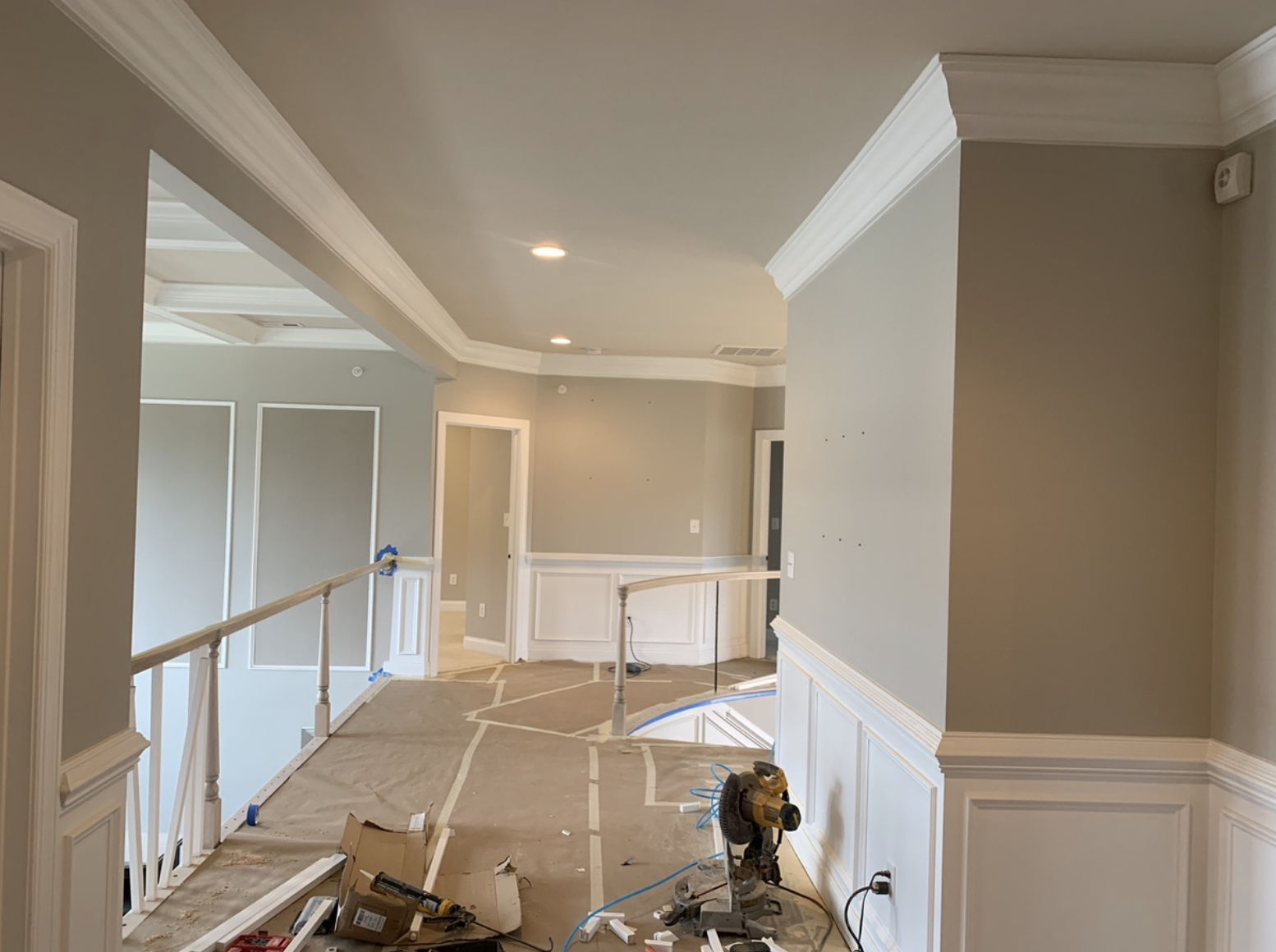 Upstairs of a home with fresh teal paint and white wainscoting and crown molding