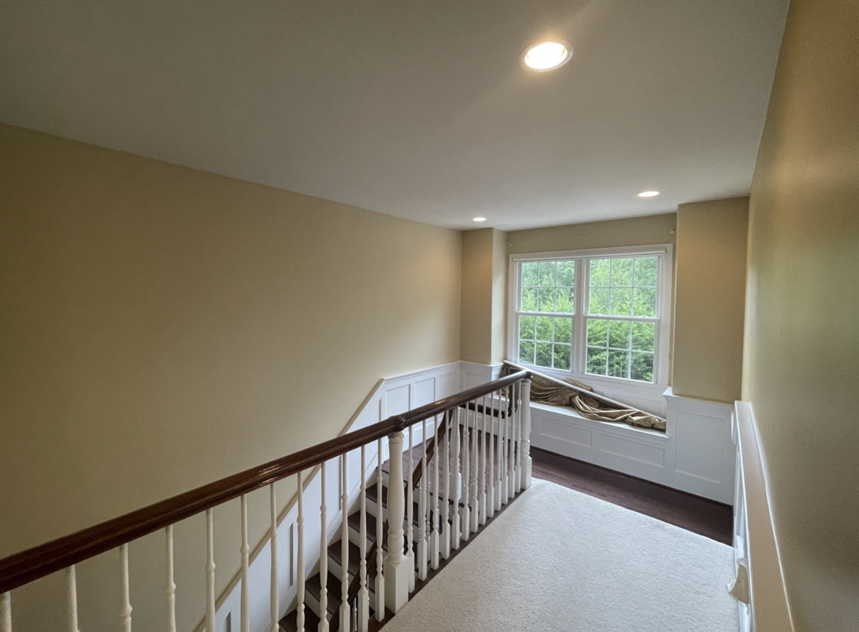Upstairs stairway area freshly painted with soft yellow walls and white trim in Downingtown, PA