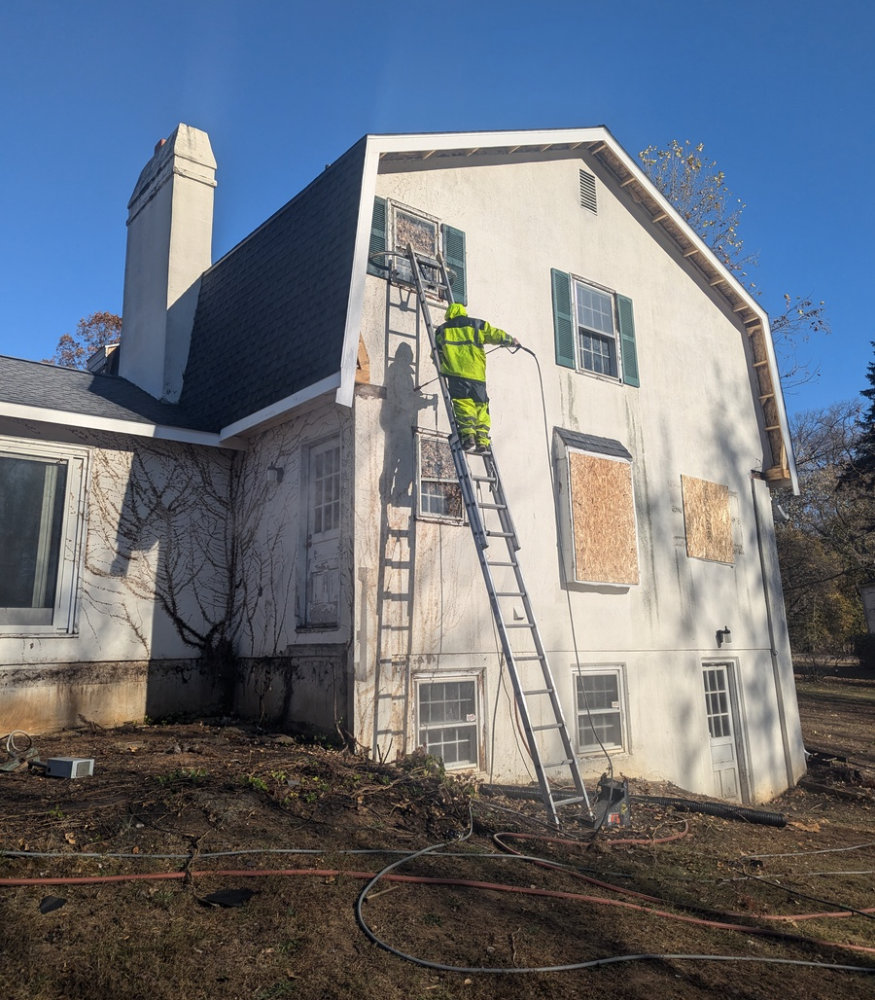 Van Horn Painting professional up on a tall ladder painting exterior of a home in West Chester PA