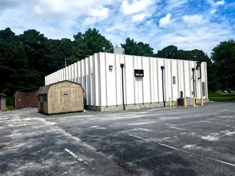 A large white building with a shed in front of it