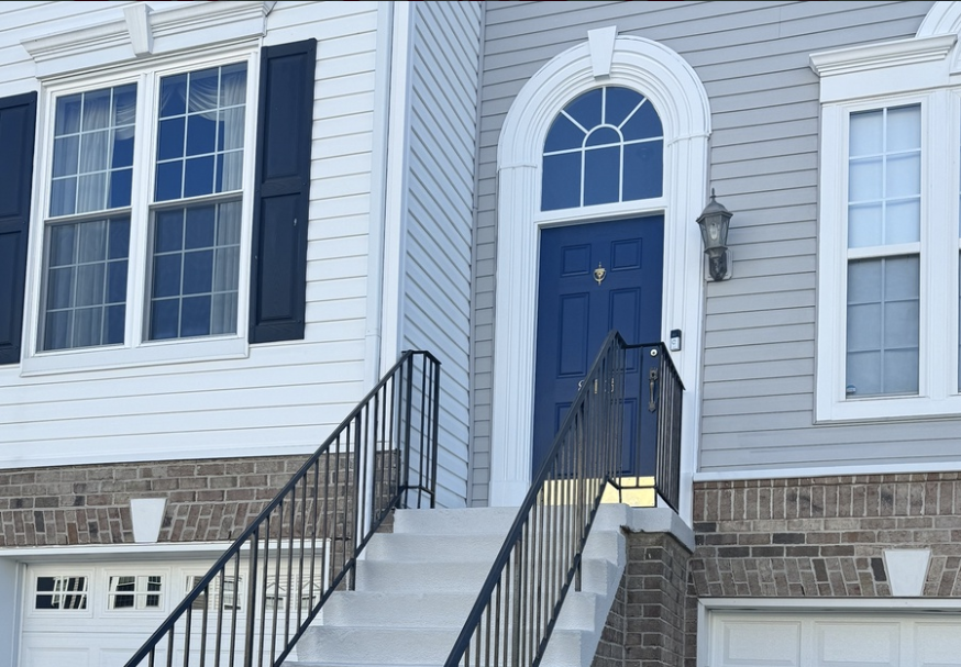 White siding facade with navy blue shutters and entry door