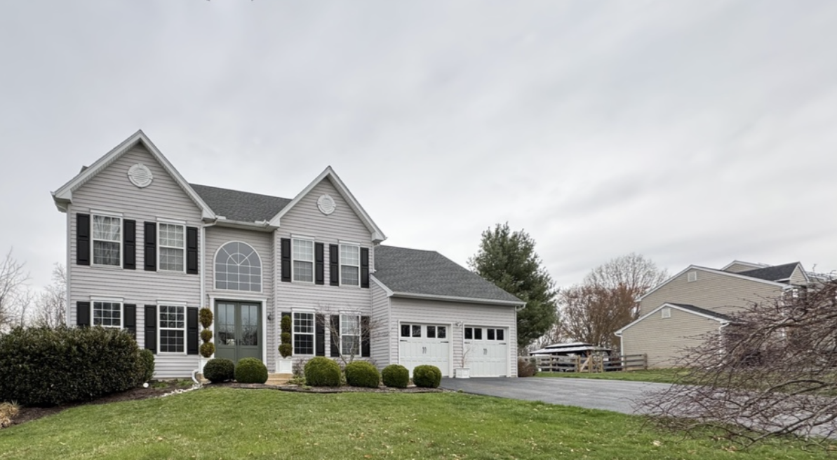 Two story home featuring soft white siding exterior, white trim, and black shutters with green front lawn