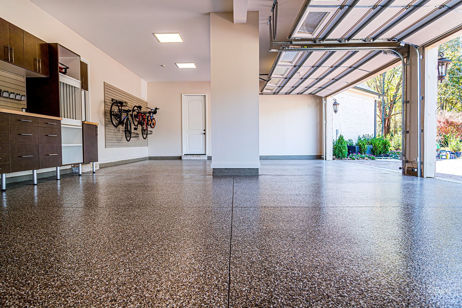 A large empty garage with a garage door open.