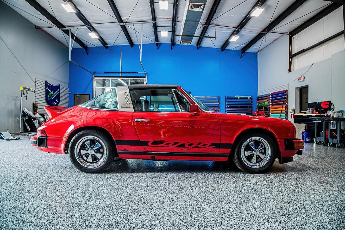 Red sports car in a window tinting shop with epoxy garage floor
