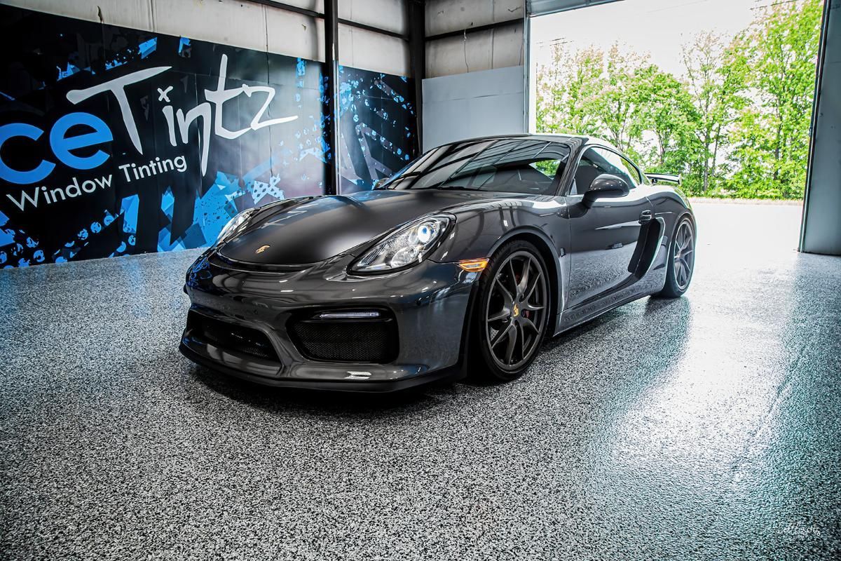 Dark gray sports car in a window tinting shop with epoxy garage floor