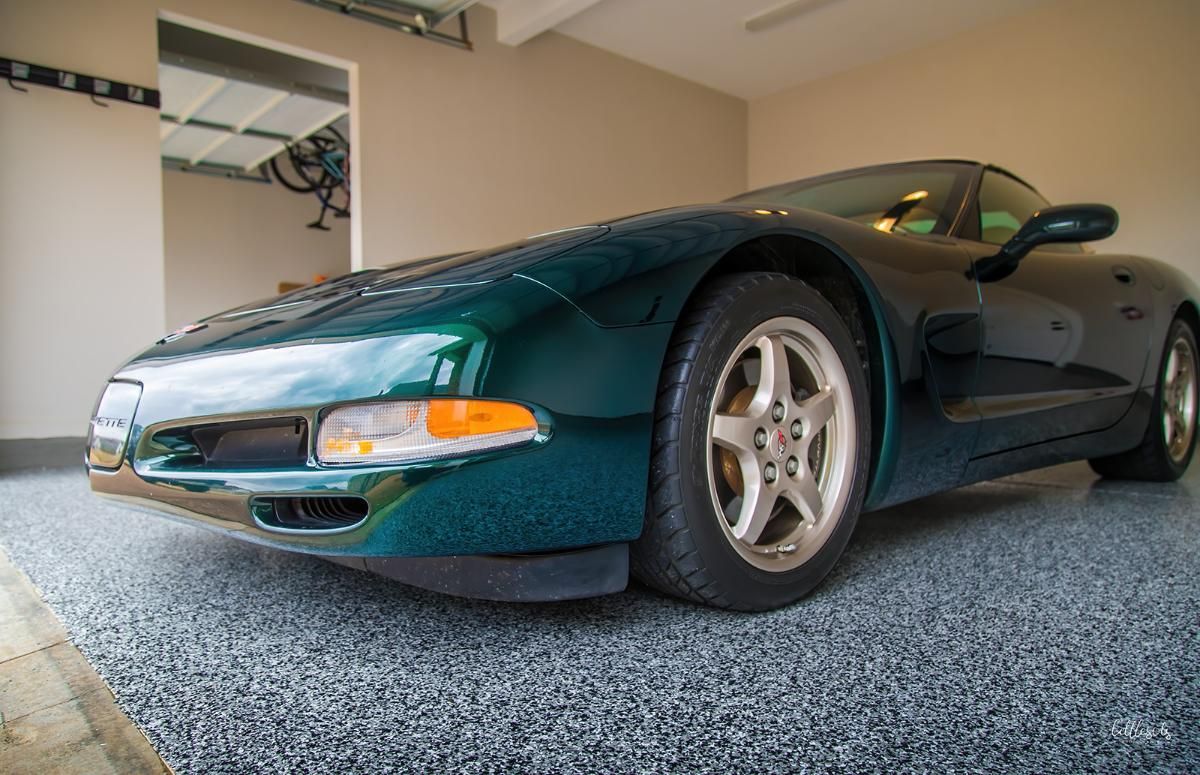 Green sports car in a garage with epoxy garage floor