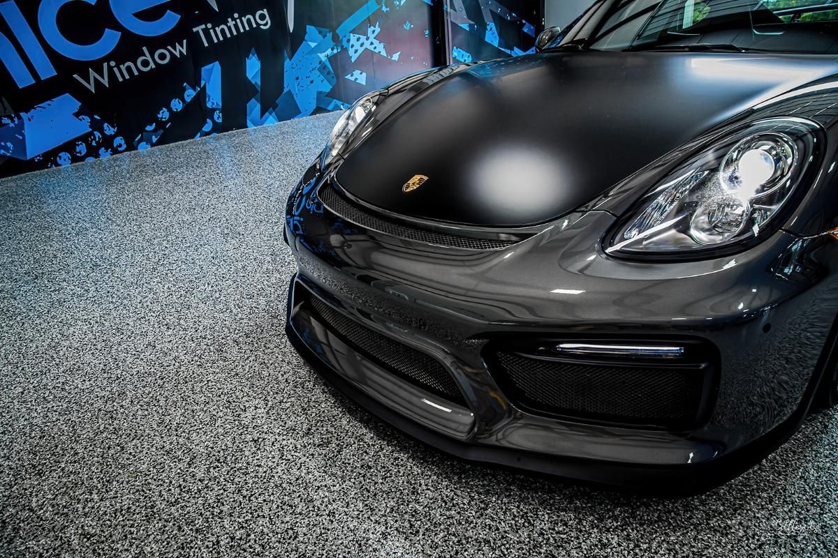 Dark gray sports car in a window tinting shop with epoxy garage floor