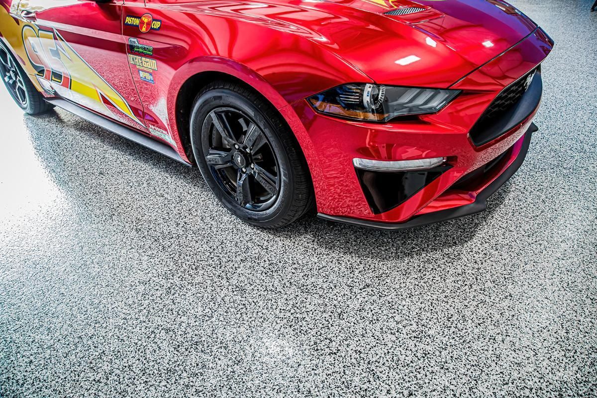 Red sports car in a window tinting shop with epoxy garage floor