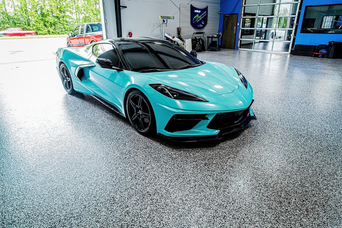 Blue sports car in a window tinting shop with epoxy garage floor