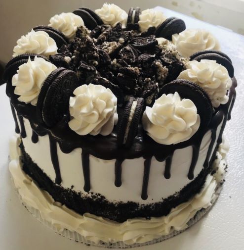 A black and white cake with oreos on top