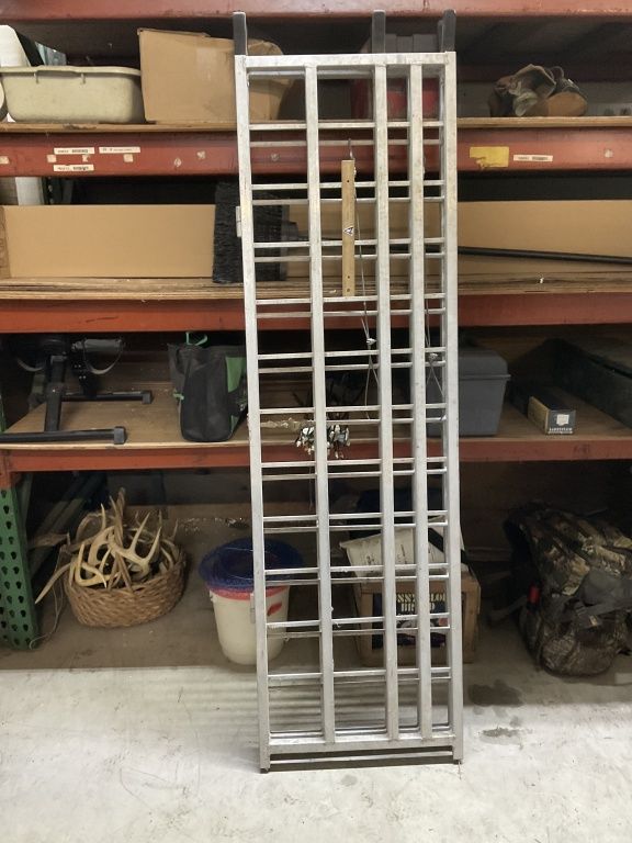 White metal shelving rack leaning in a garage with boxes and storage items on shelves.