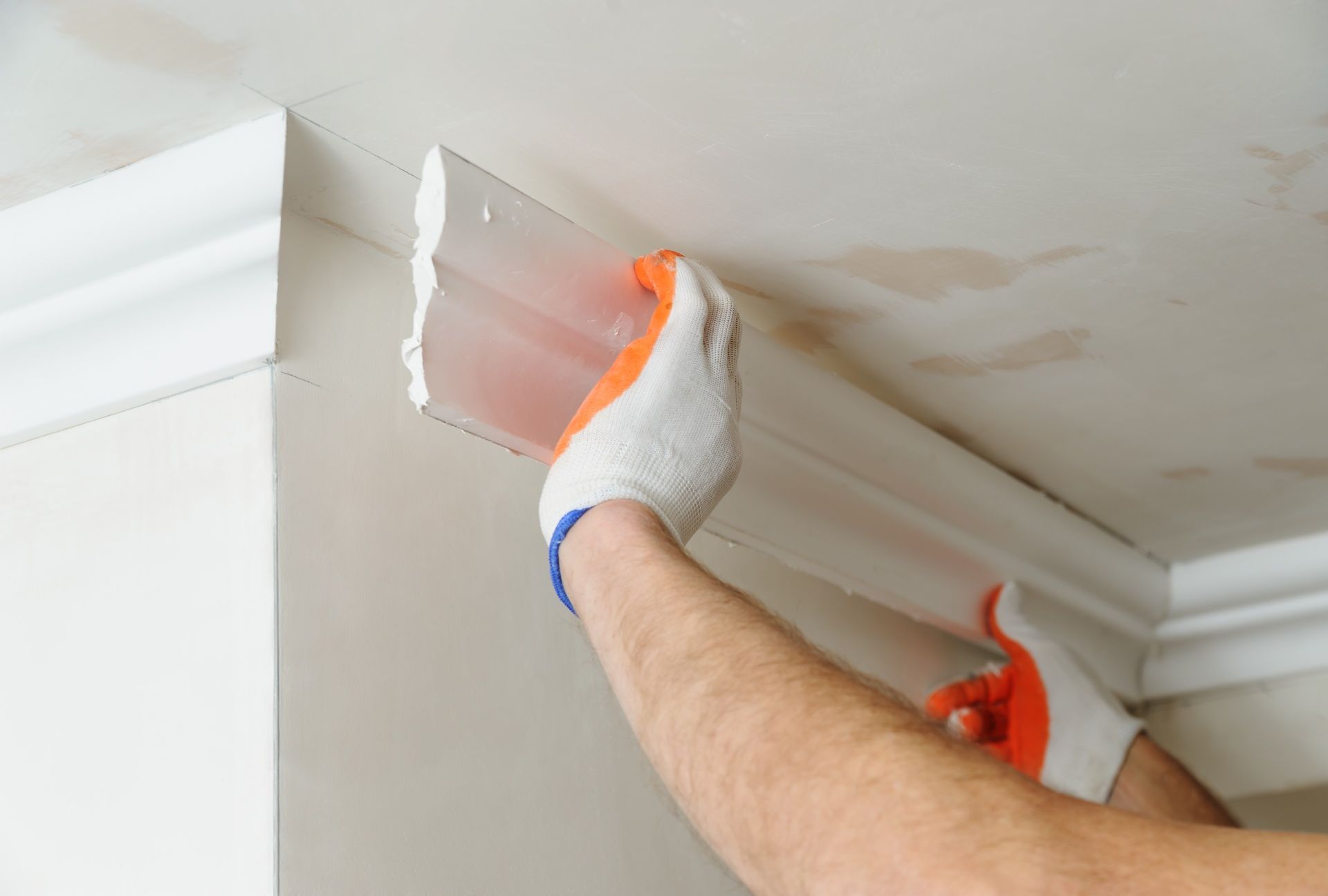 A man is plastering a corner of a wall with a spatula.
