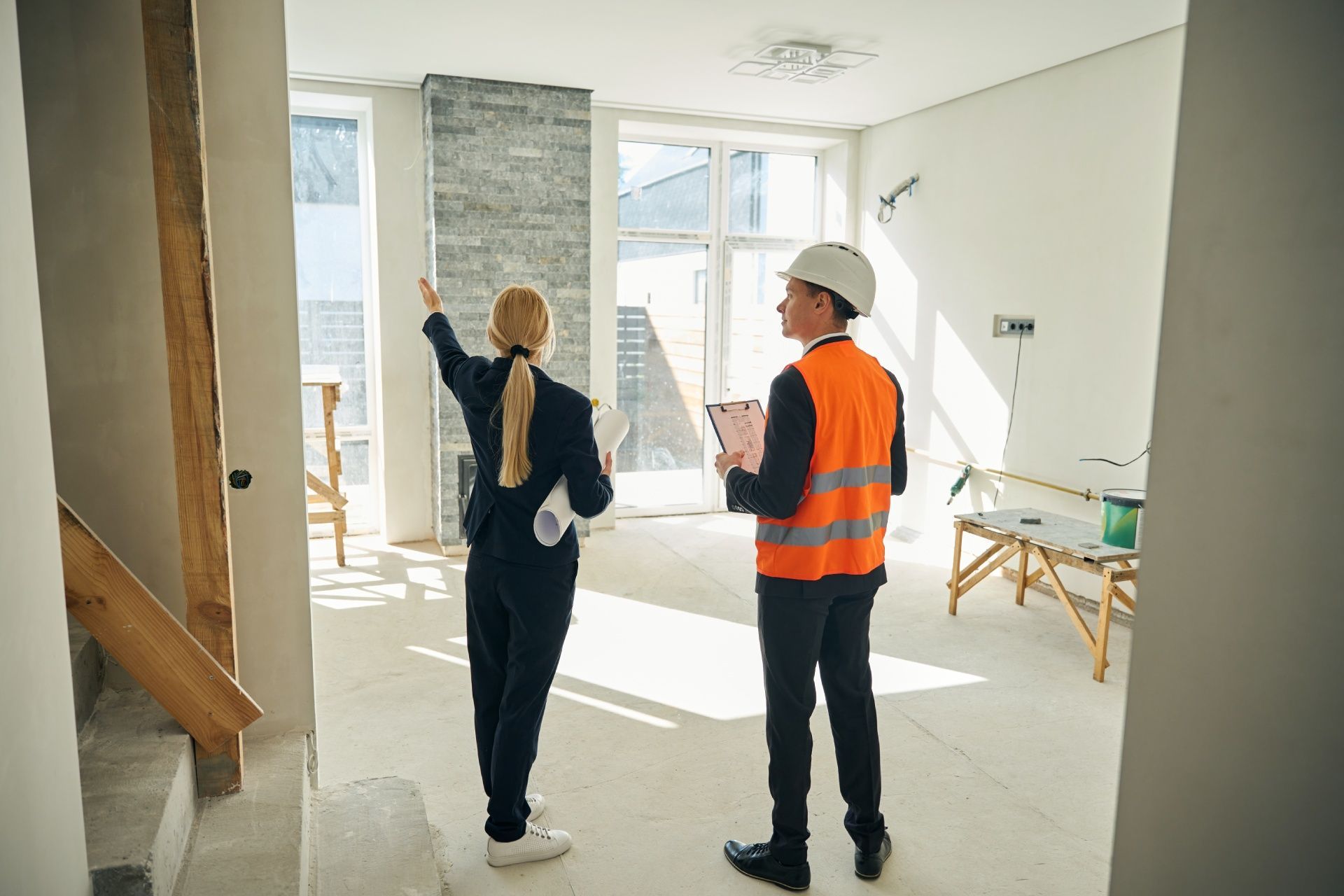 A man and a woman are looking at a house under construction.