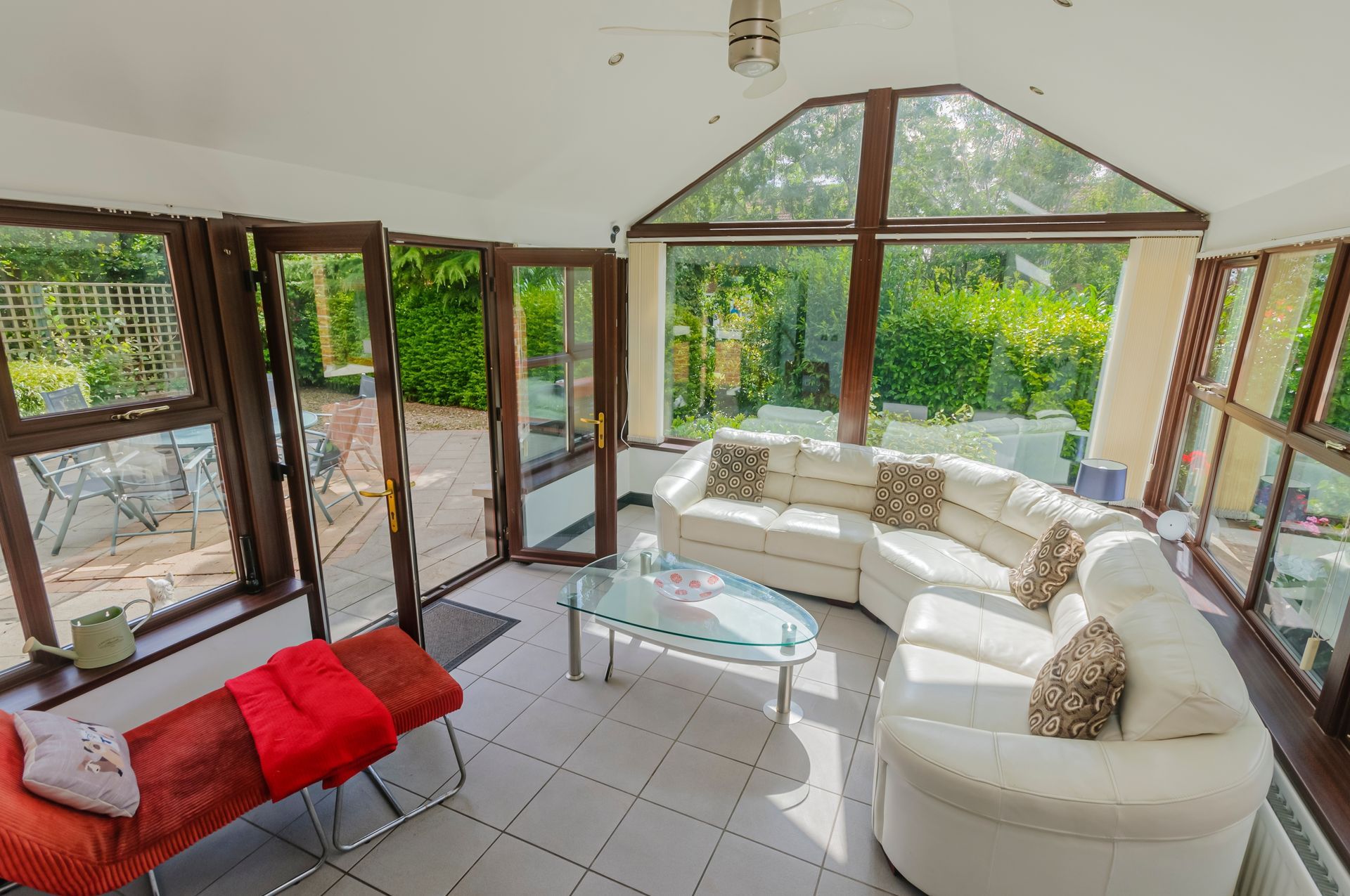 A living room with a couch , chair , coffee table and lots of windows.
