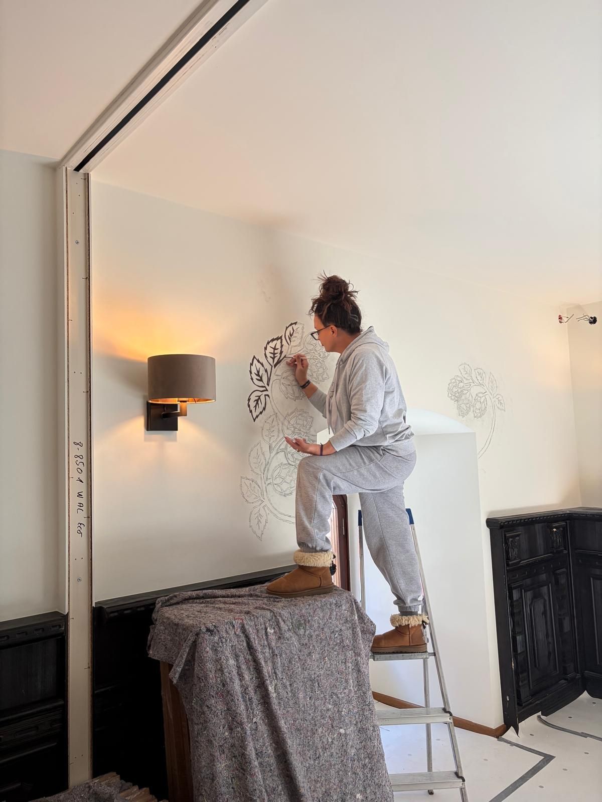 Malerin malt Hopfen an die Wand