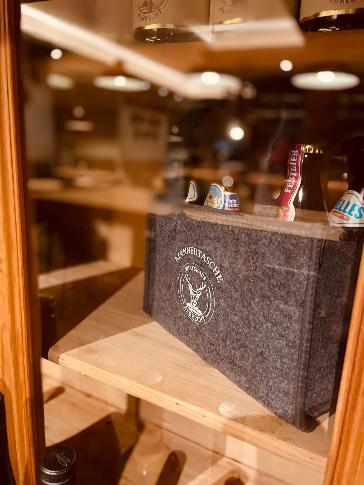 Herrentasche aus grauen Filz mit sechs verschiedenen Bieren.