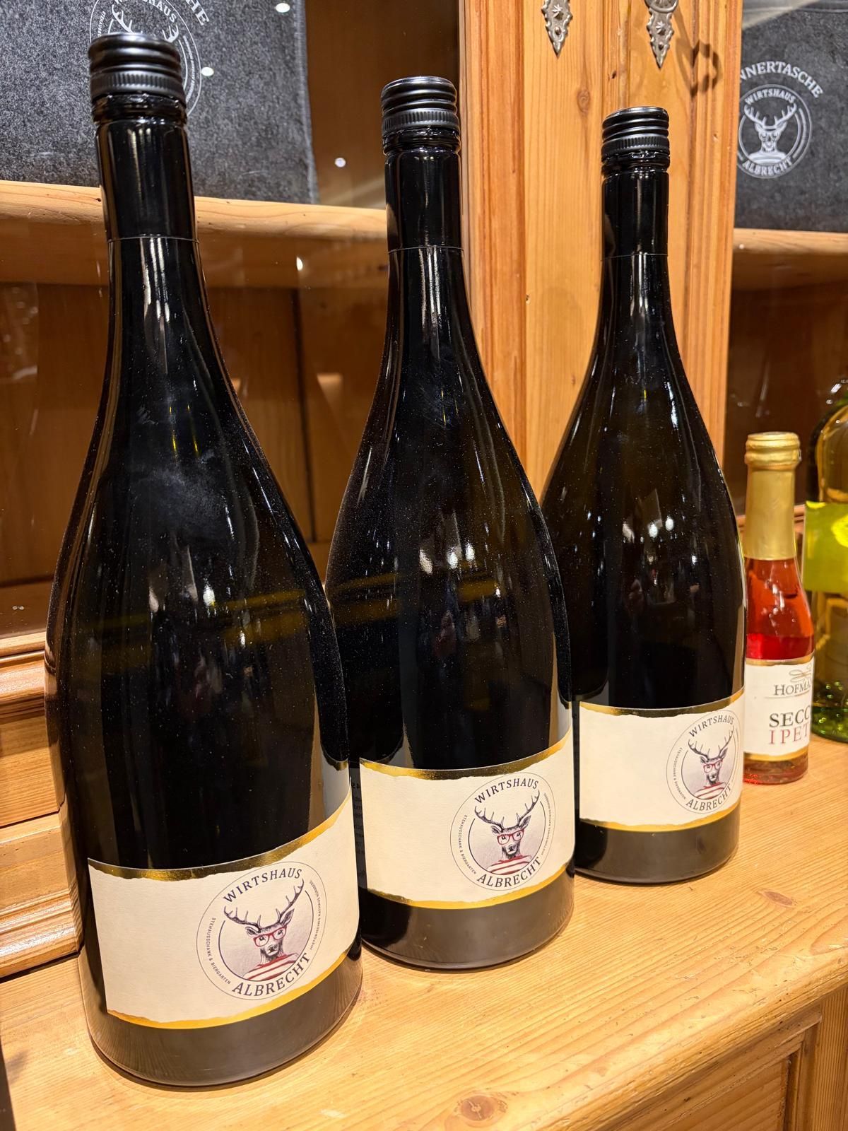 Drei Proseccoflaschen mit dem Albrechtlogo als Etikett.