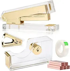 Gold and clear plastic office supplies: stapler, tape dispenser, tape roll, and staples on white background