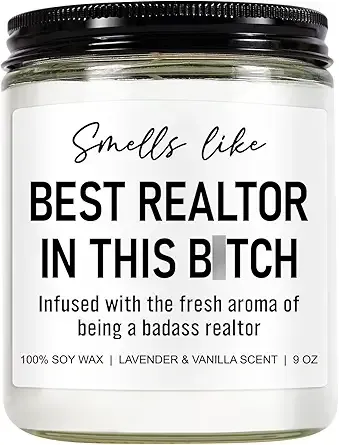 White candle with black lid labeled “Smells like BEST REALTOR IN THIS BITCH” and lavender vanilla scent.