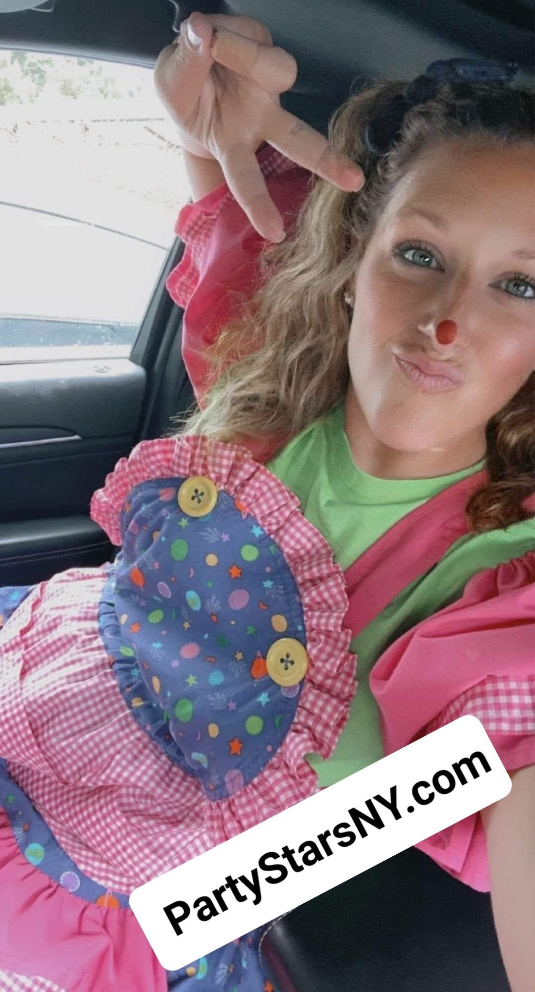 A woman in a clown costume is sitting in a car.