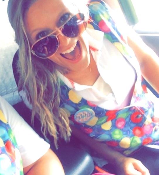 A woman wearing sunglasses and an apron that says ' coca cola ' on it