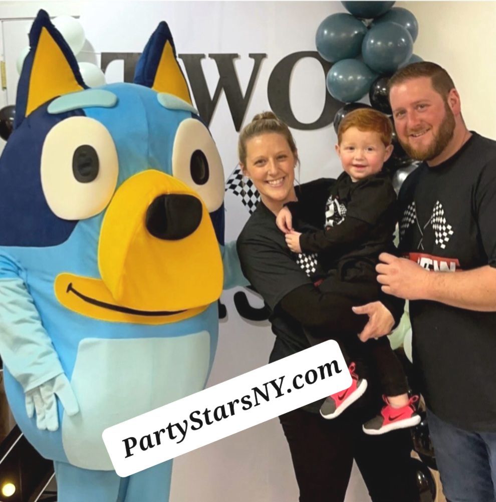 A woman holding a child next to a blue dog mascot from partystarsny.com