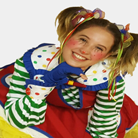 A girl in a clown costume is smiling for the camera