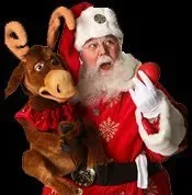 Santa claus is holding a stuffed reindeer in his arms.