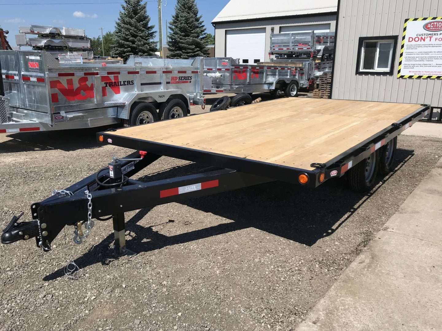 Car trailer with ramps on gravel.