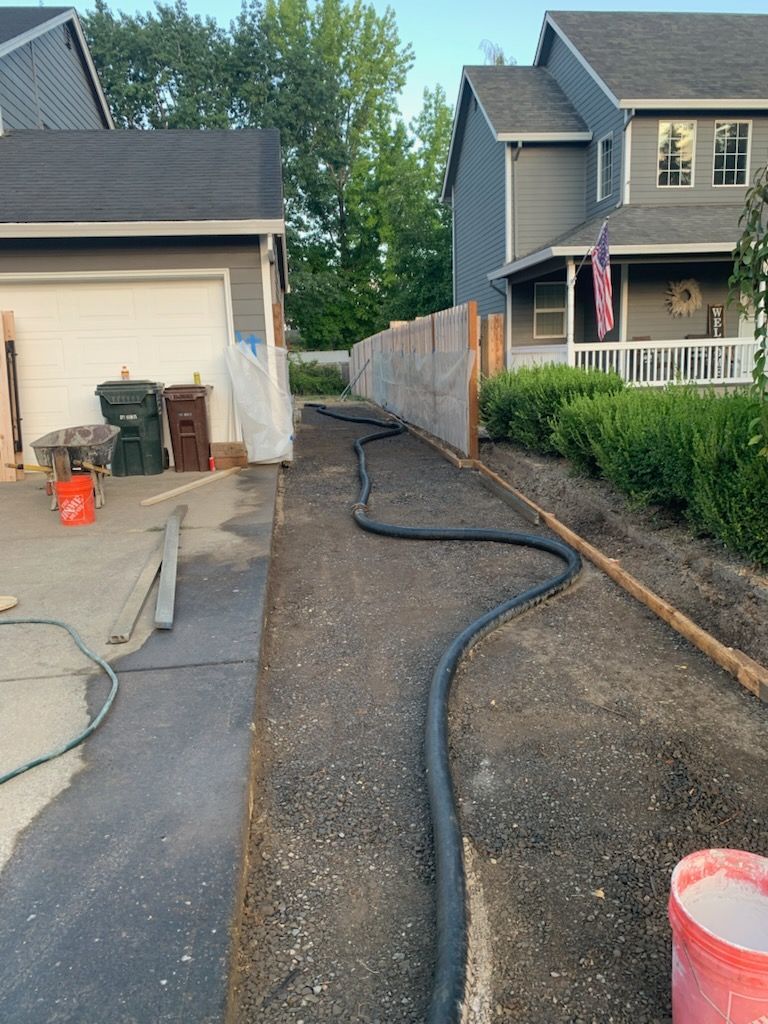 Fresh concrete being poured and leveled over rebar at a construction site at sunset