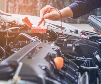 A mechanic is working on the engine of a car.