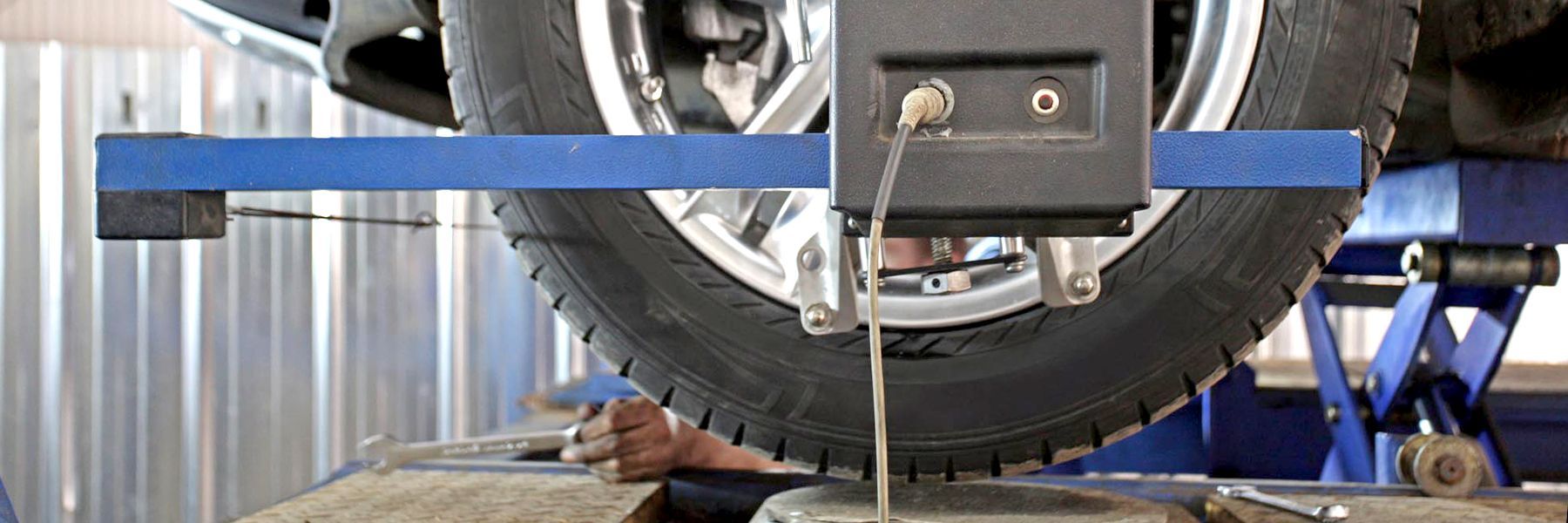 A man in a blue shirt is working on a brake disc on a car.
