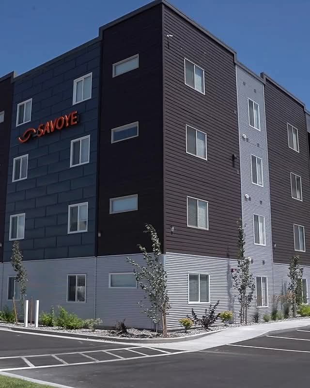 Modern apartment building with grey, black, and brown panels.