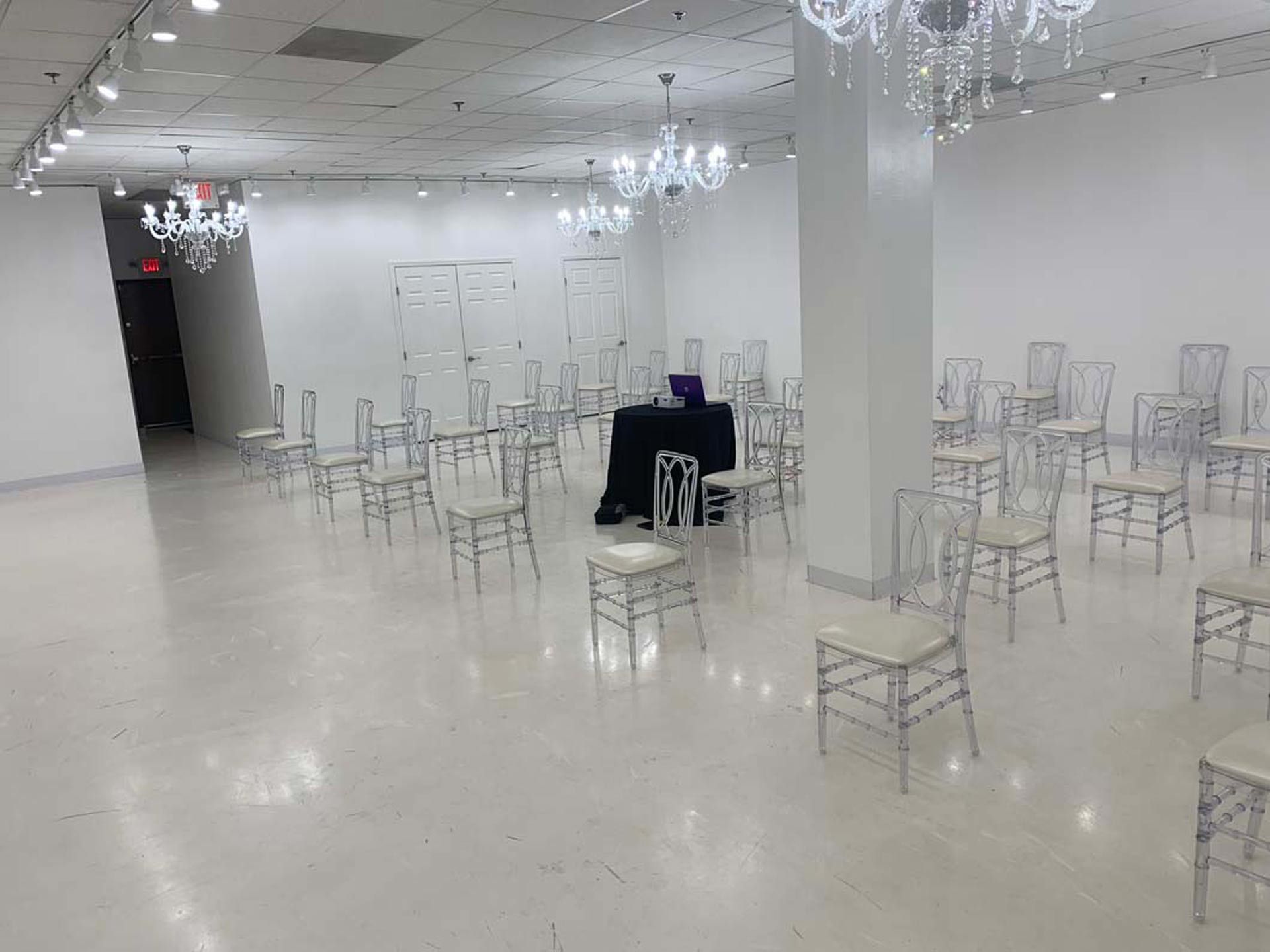 A large room filled with white chairs and a table