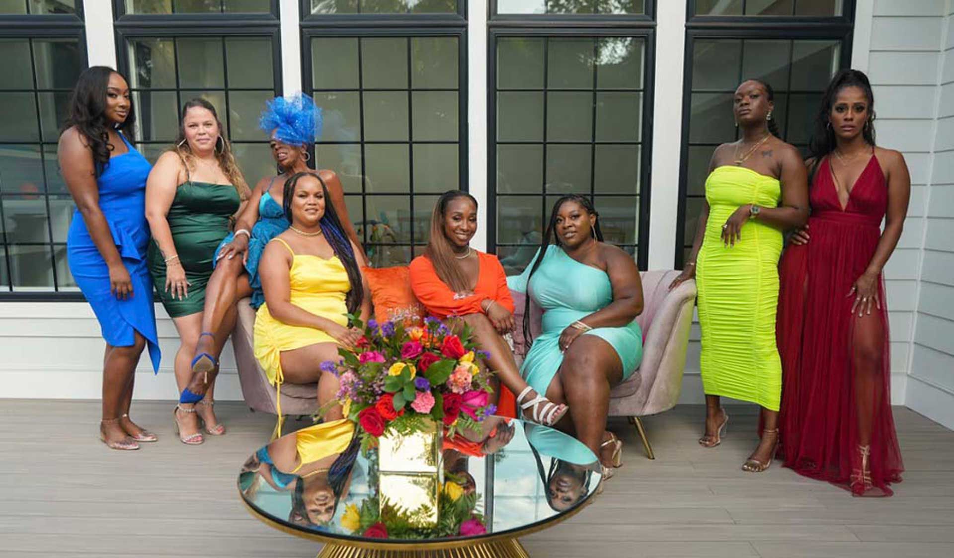 A group of women are posing for a picture while sitting around a table