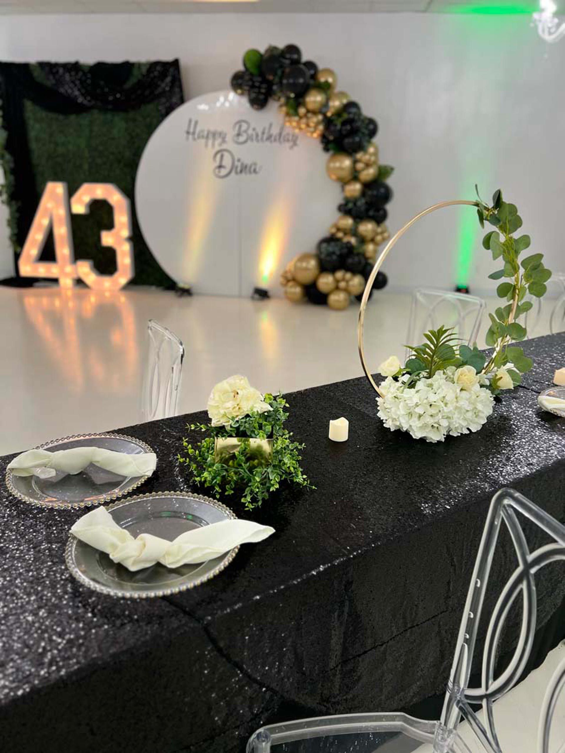 A table set for a birthday party with plates and flowers on it
