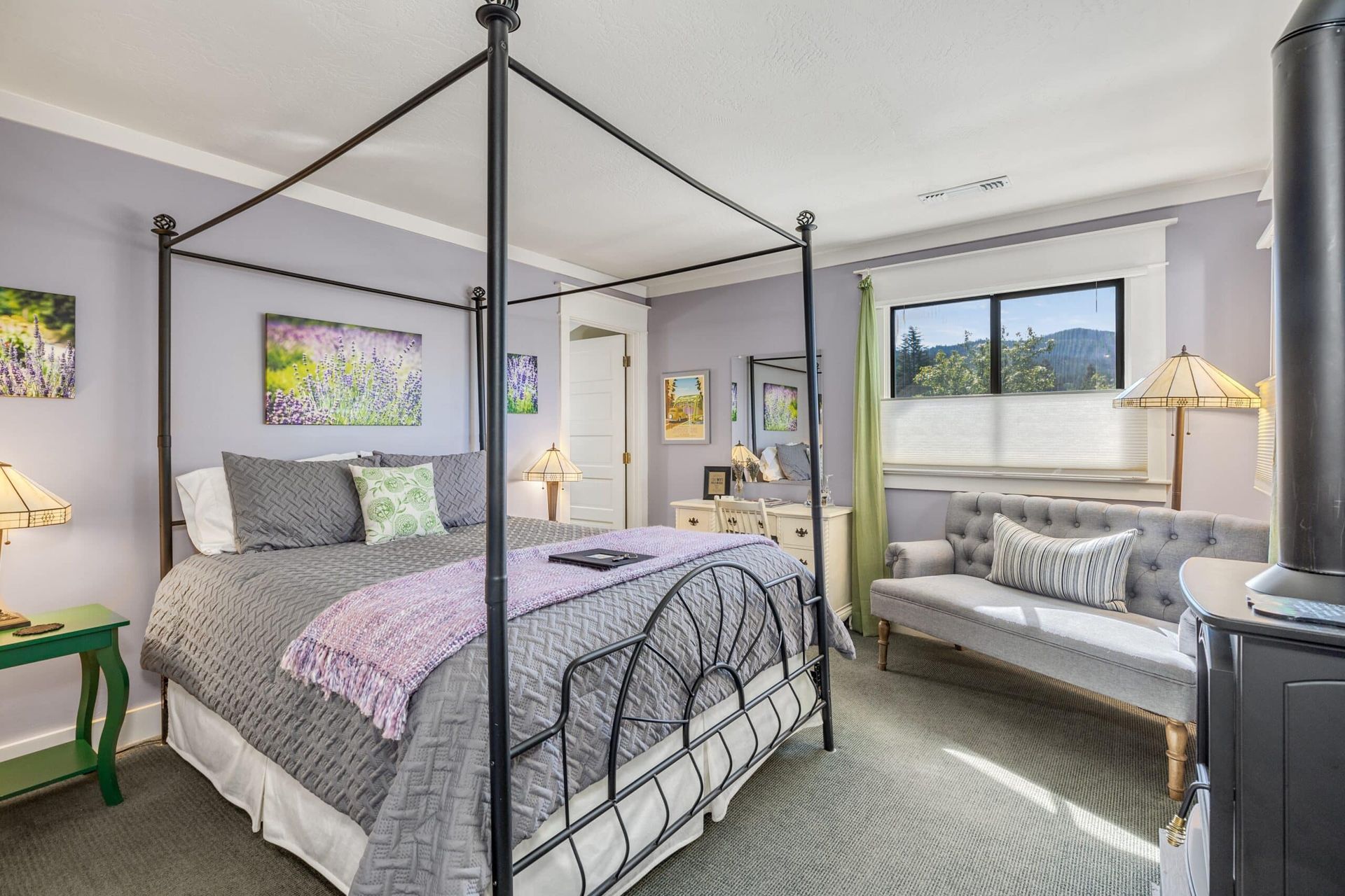 A bedroom with a four poster bed and a couch.