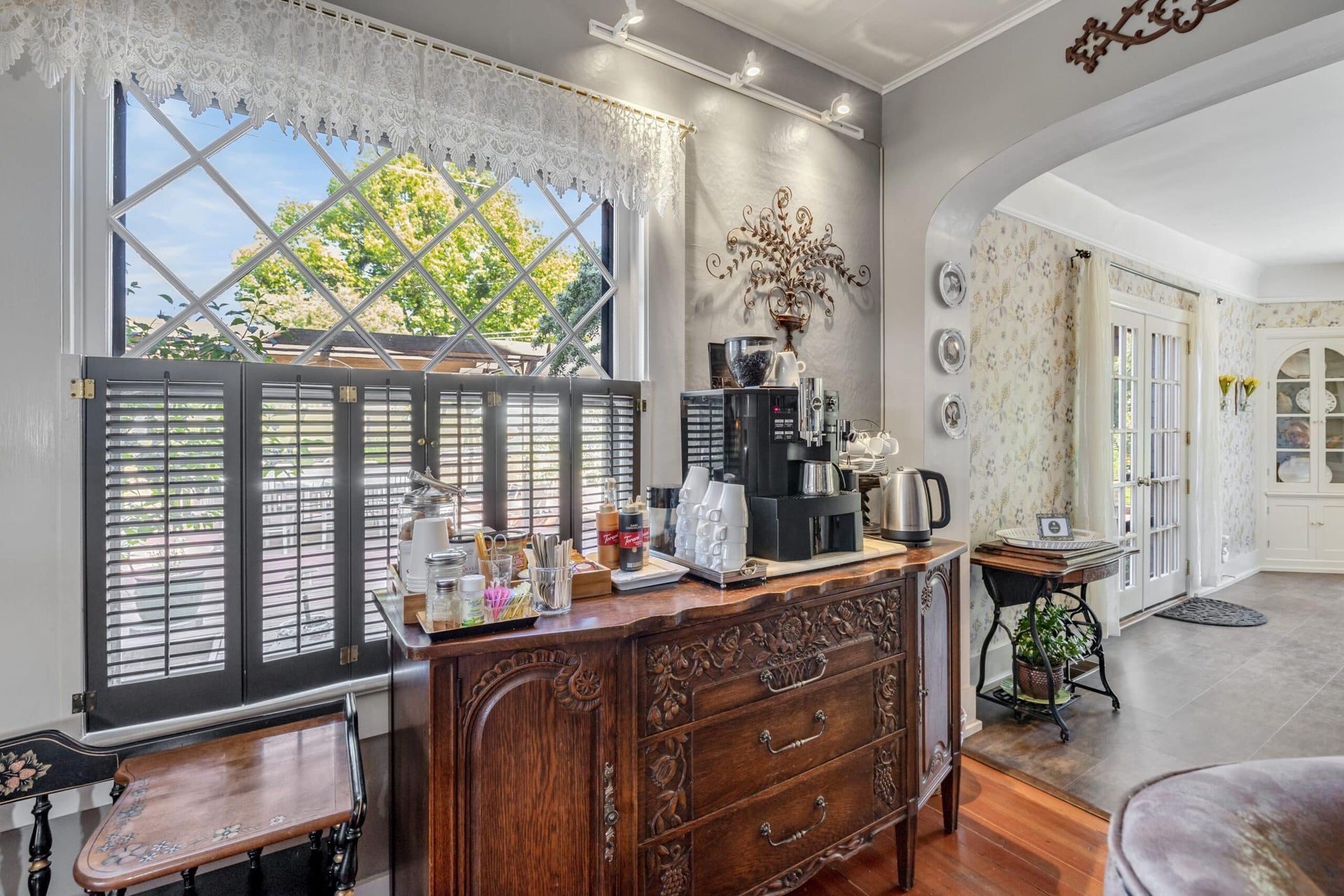 A living room with a coffee bar and a window.