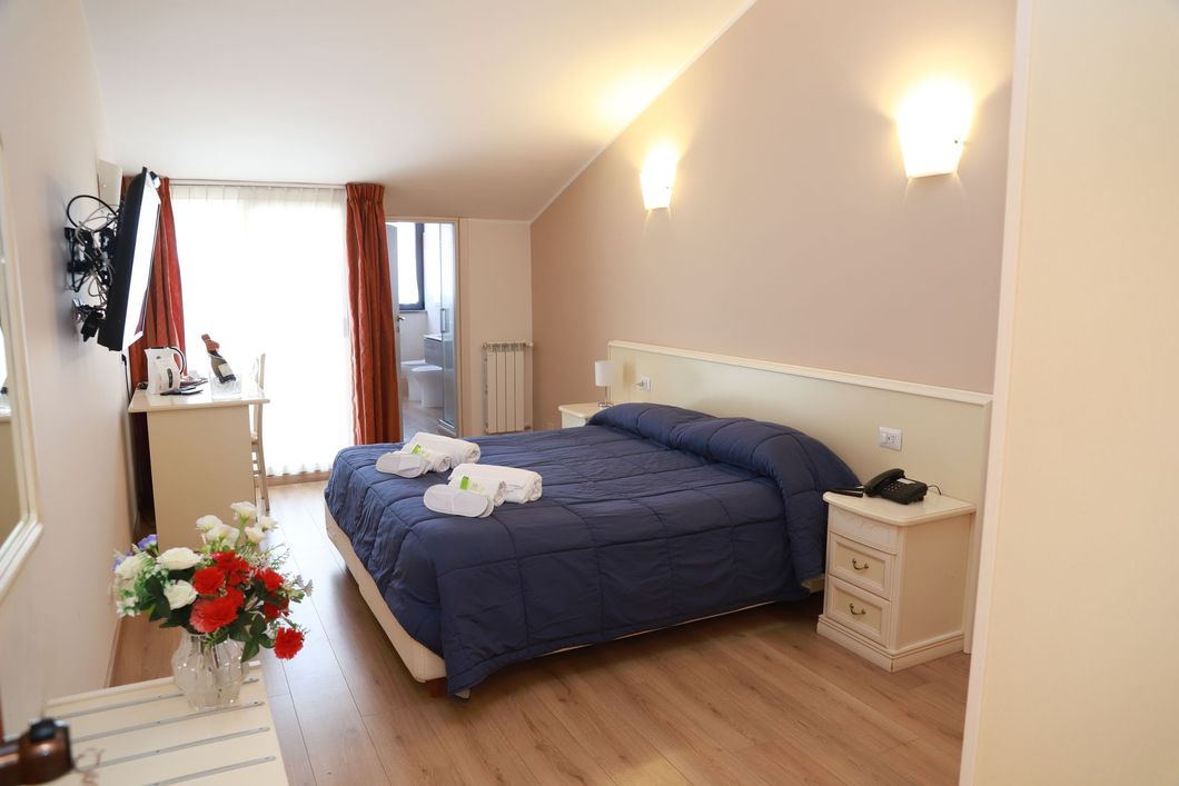 Una camera da letto con un letto, un comodino e una lampada.