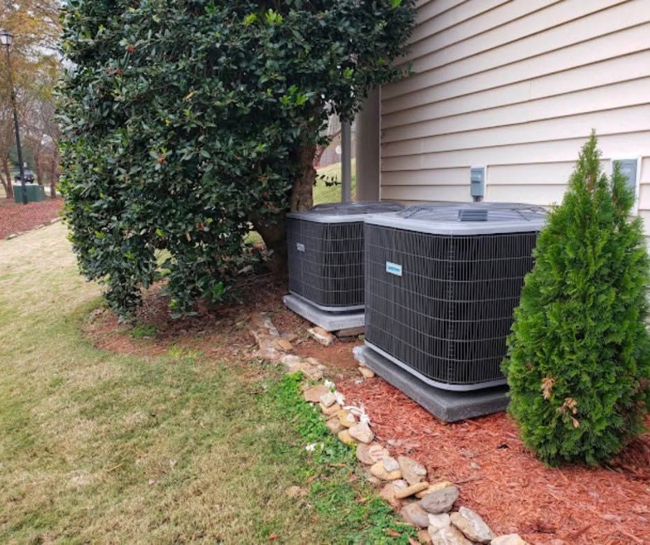 Person crouching in a narrow utility space, inspecting HVAC ducting and equipment.