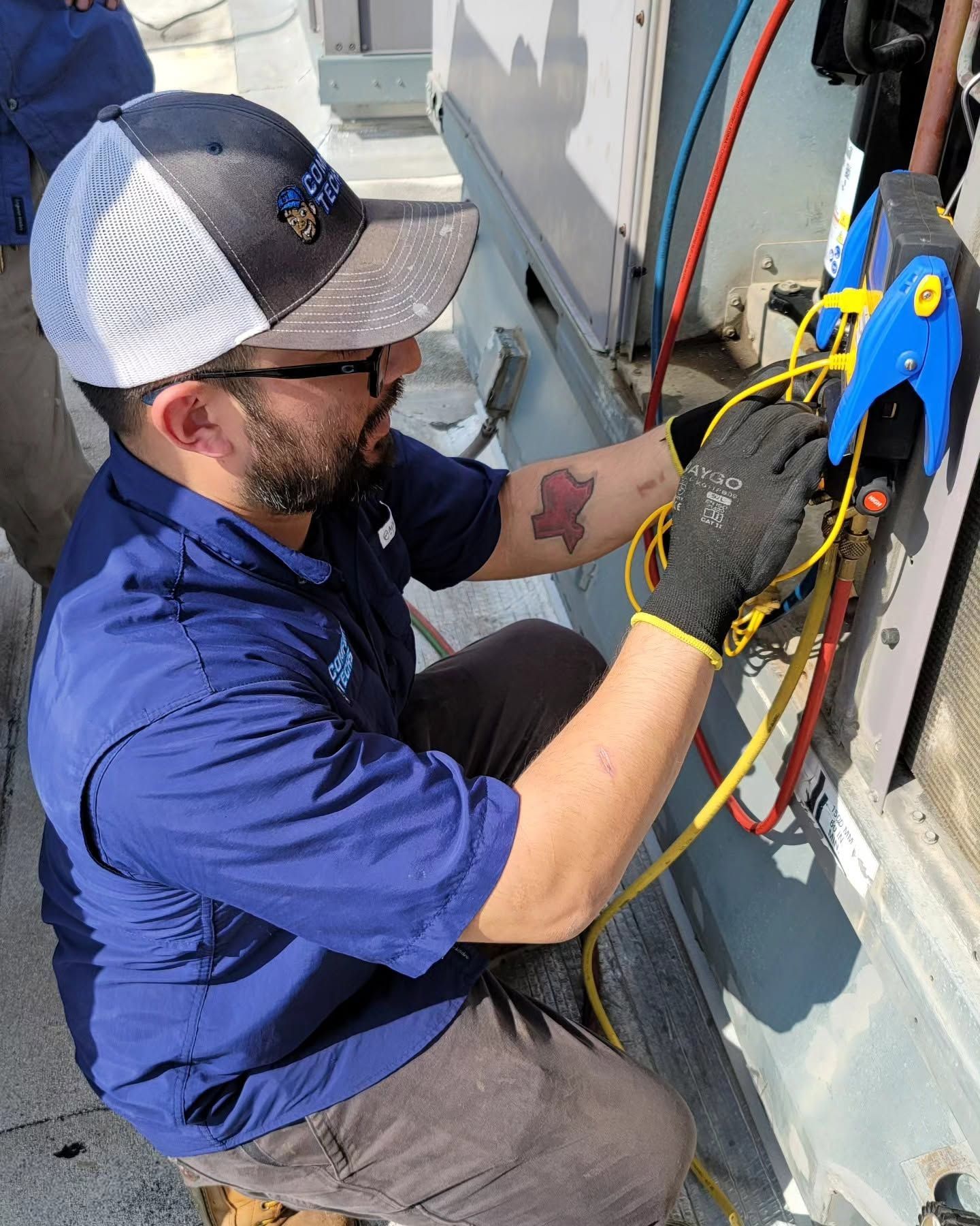 Person crouching in a narrow utility space, inspecting HVAC ducting and equipment.