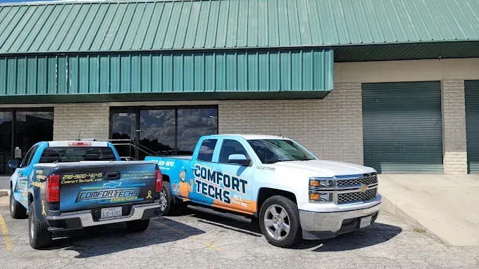 Two parked service trucks with “Remote Techs” branding outside a building with green awnings.