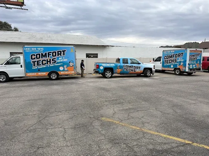 Three Comfort Techs service trucks and trailers parked on a lot under an overcast sky.
