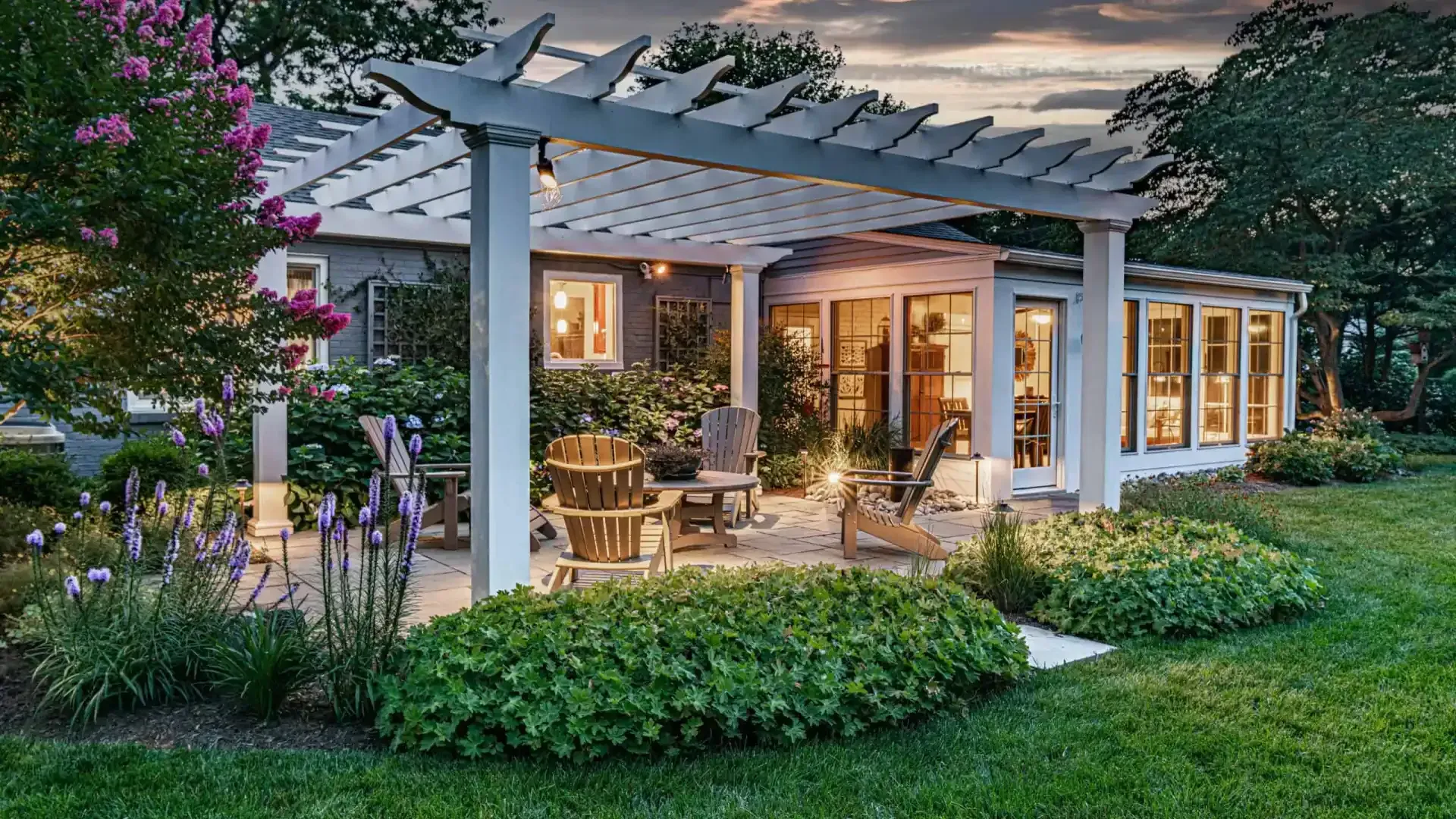 Cozy garden patio with pergola, warm lights, outdoor seating, and lush landscaping at dusk
