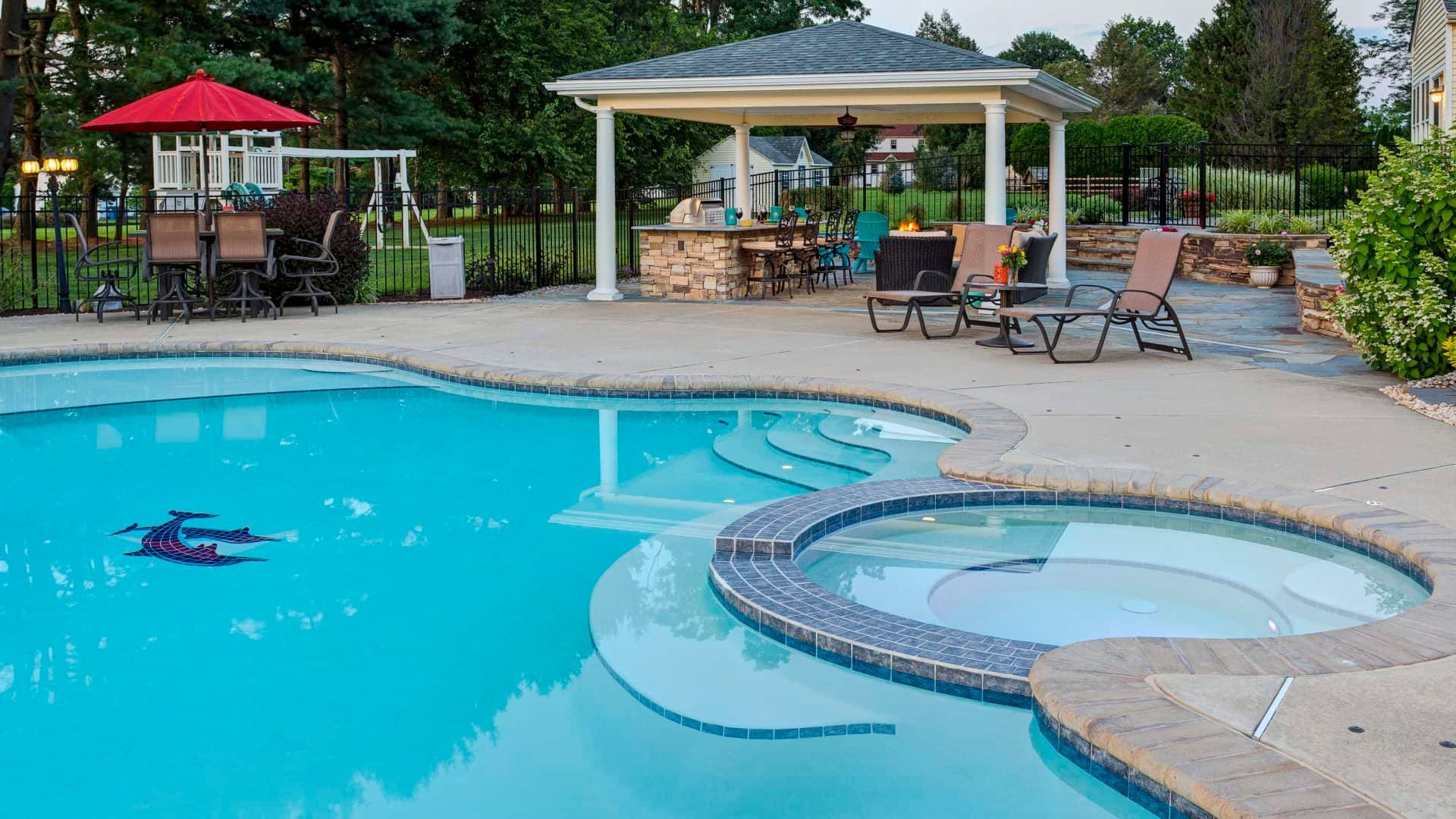 Backyard pool with a hot tub, lounge chairs, and shaded cabana seating area