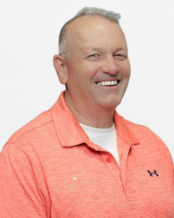 Smiling man in a coral polo shirt against a white background