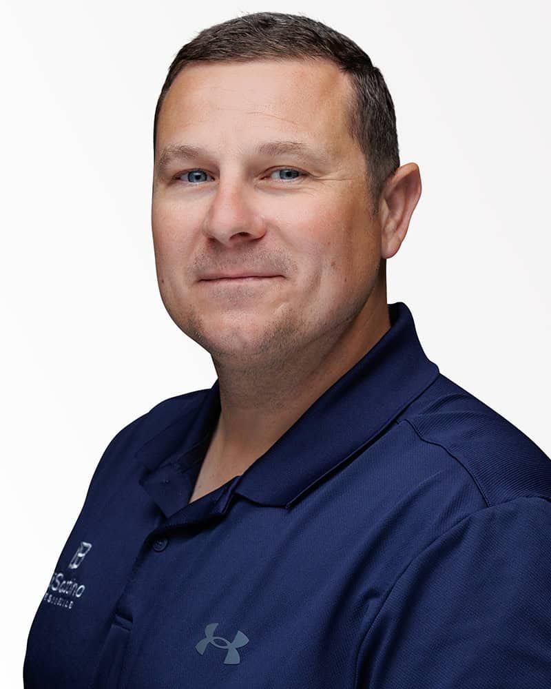 Portrait of a man in a navy polo shirt against a white background