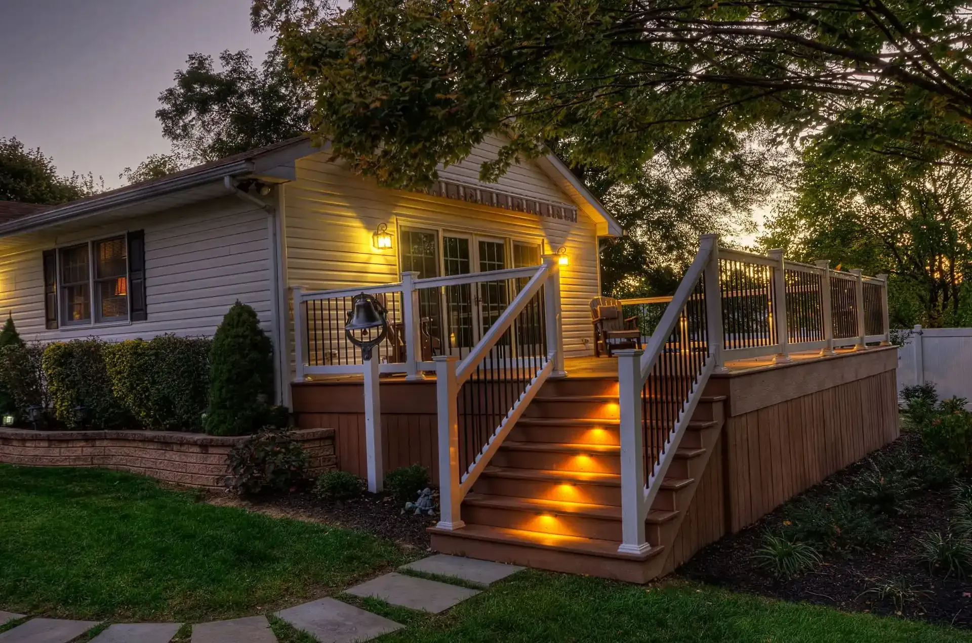 House porch with glowing steps and warm lights at dusk